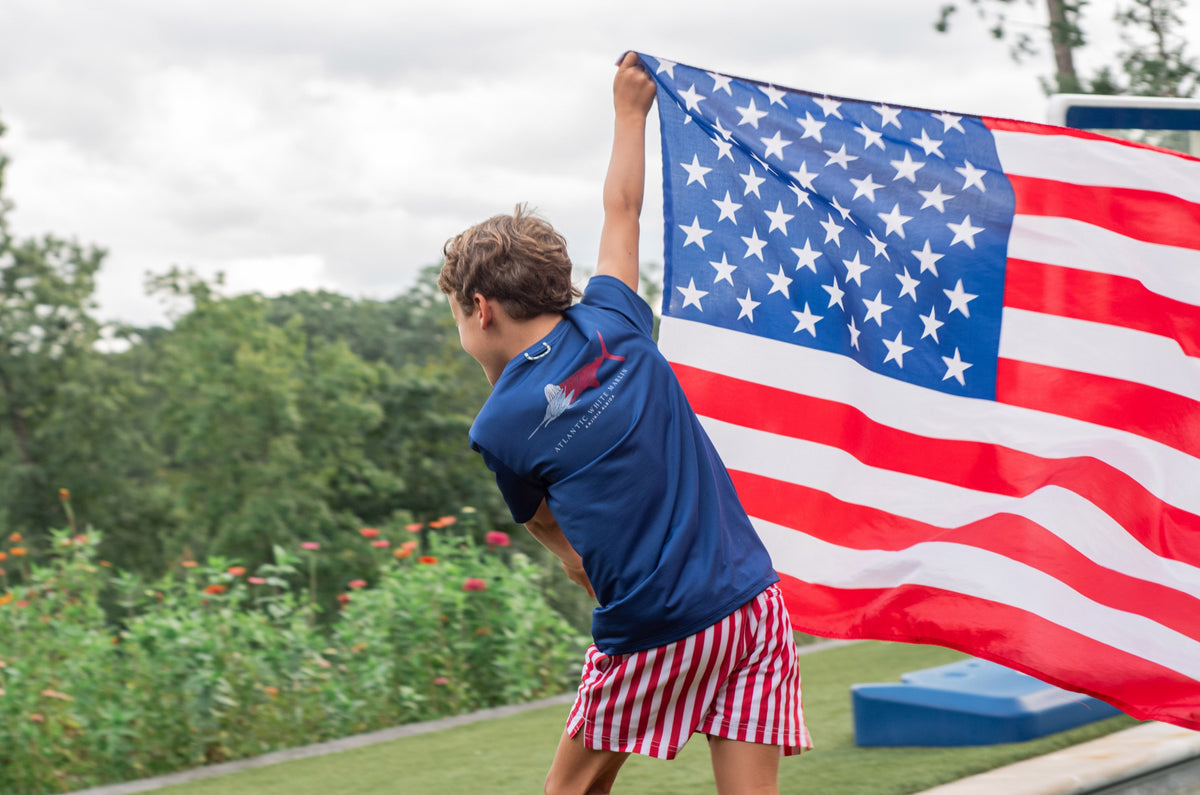 Person holding an American flag wearing Quick-Dry Anti-Chafe swim shorts