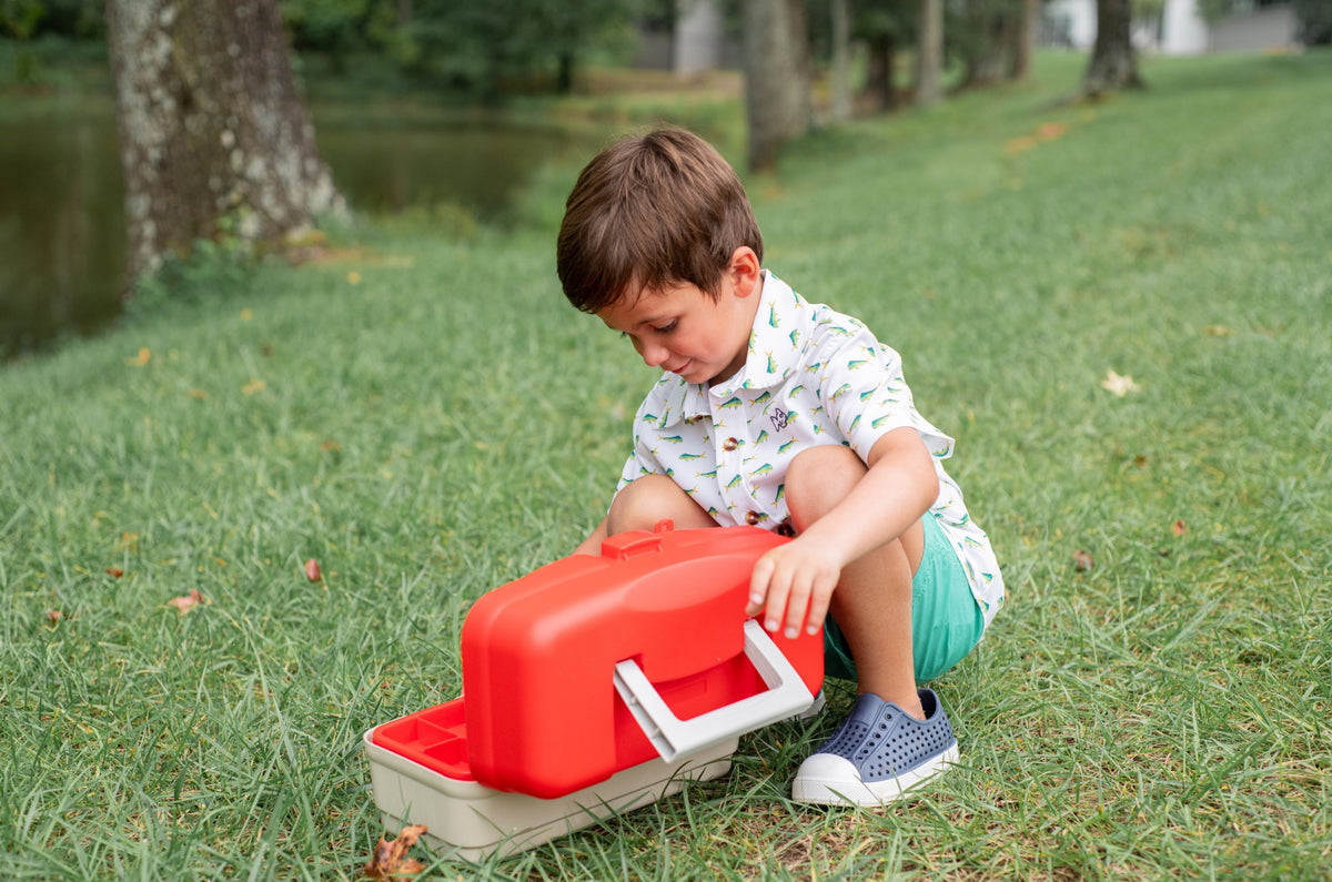 Child wearing fishting shirt opening a tackle box