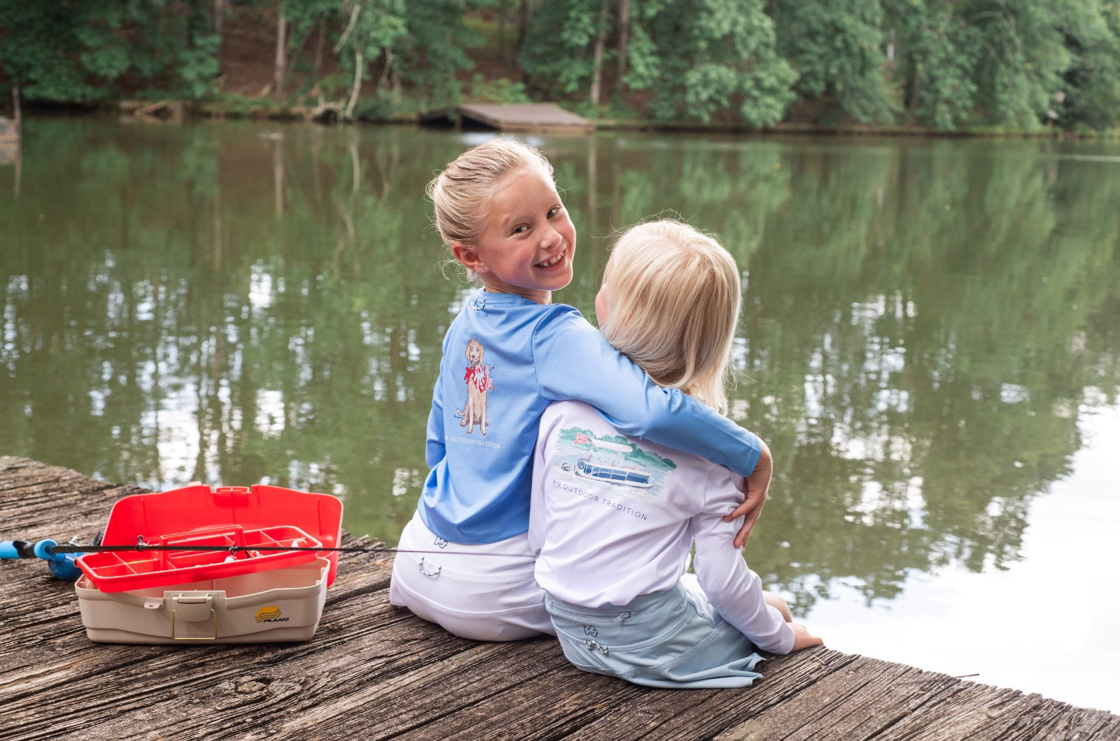Two children sitting on a dock by a lake with wearing  Long Sleeve T-shirt – Patriotic Pup Art