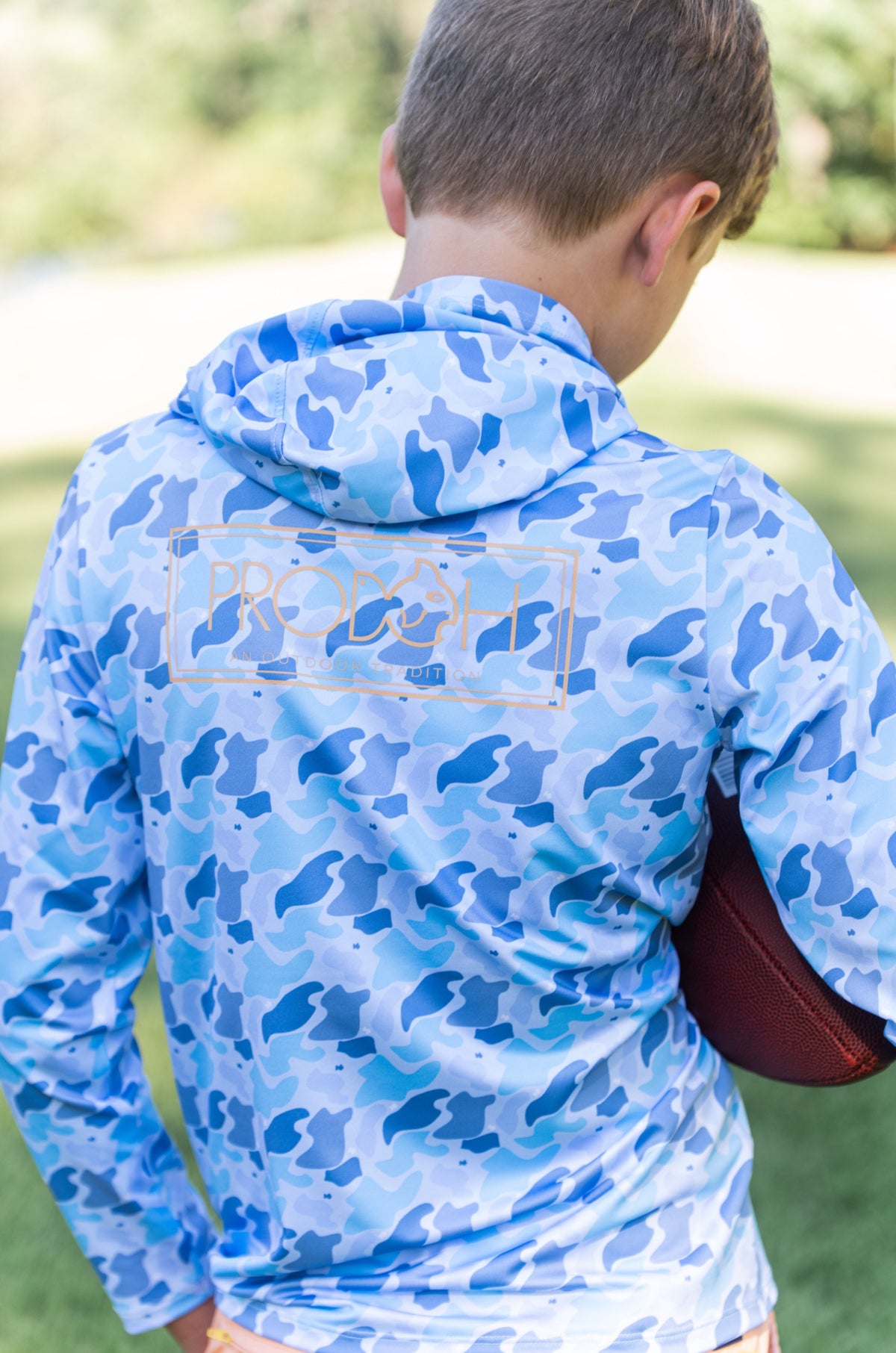 young boy wearing a blue camouflage hoodie