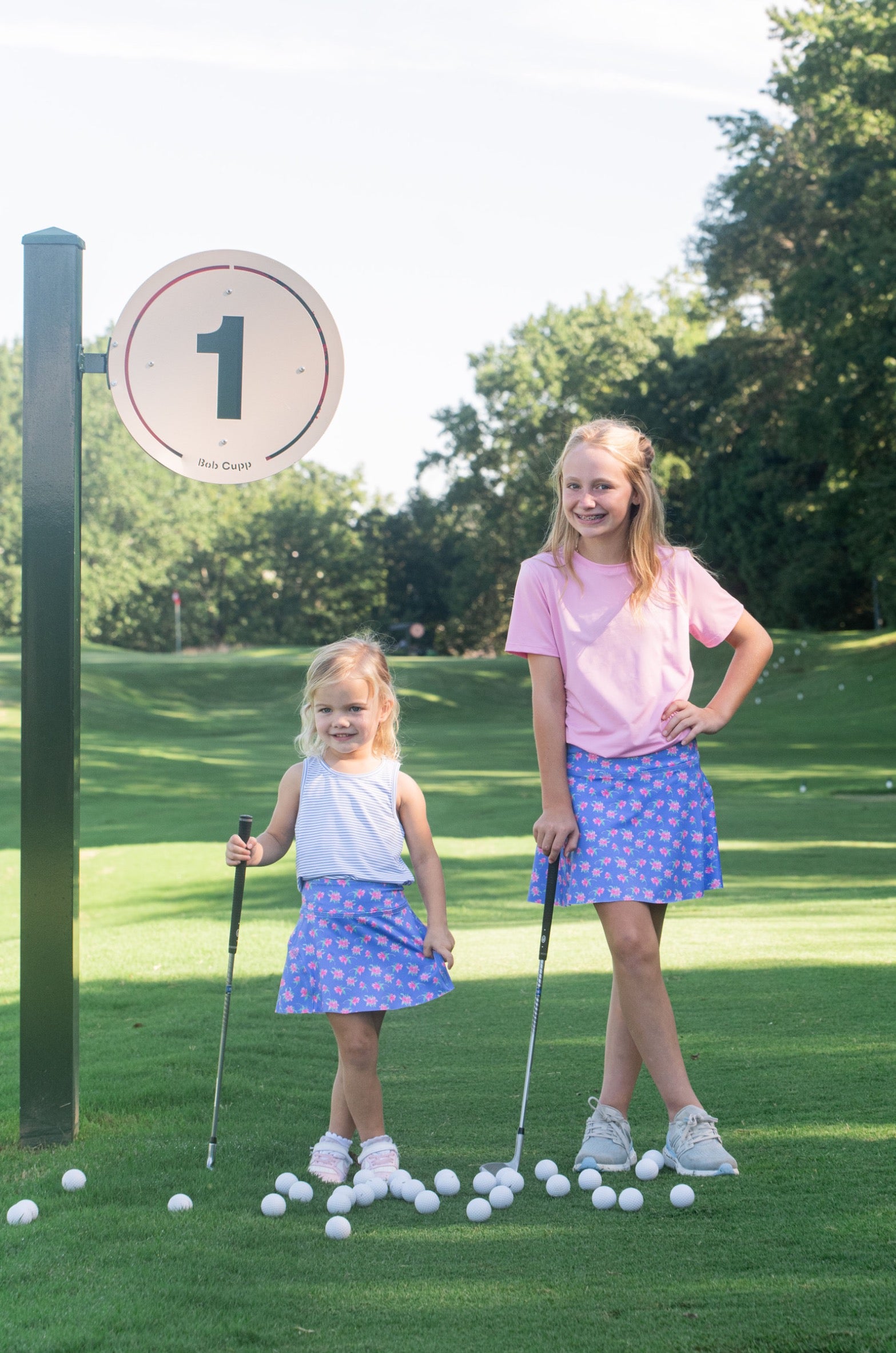 Two young girls on a golf course wearing athletic skorts