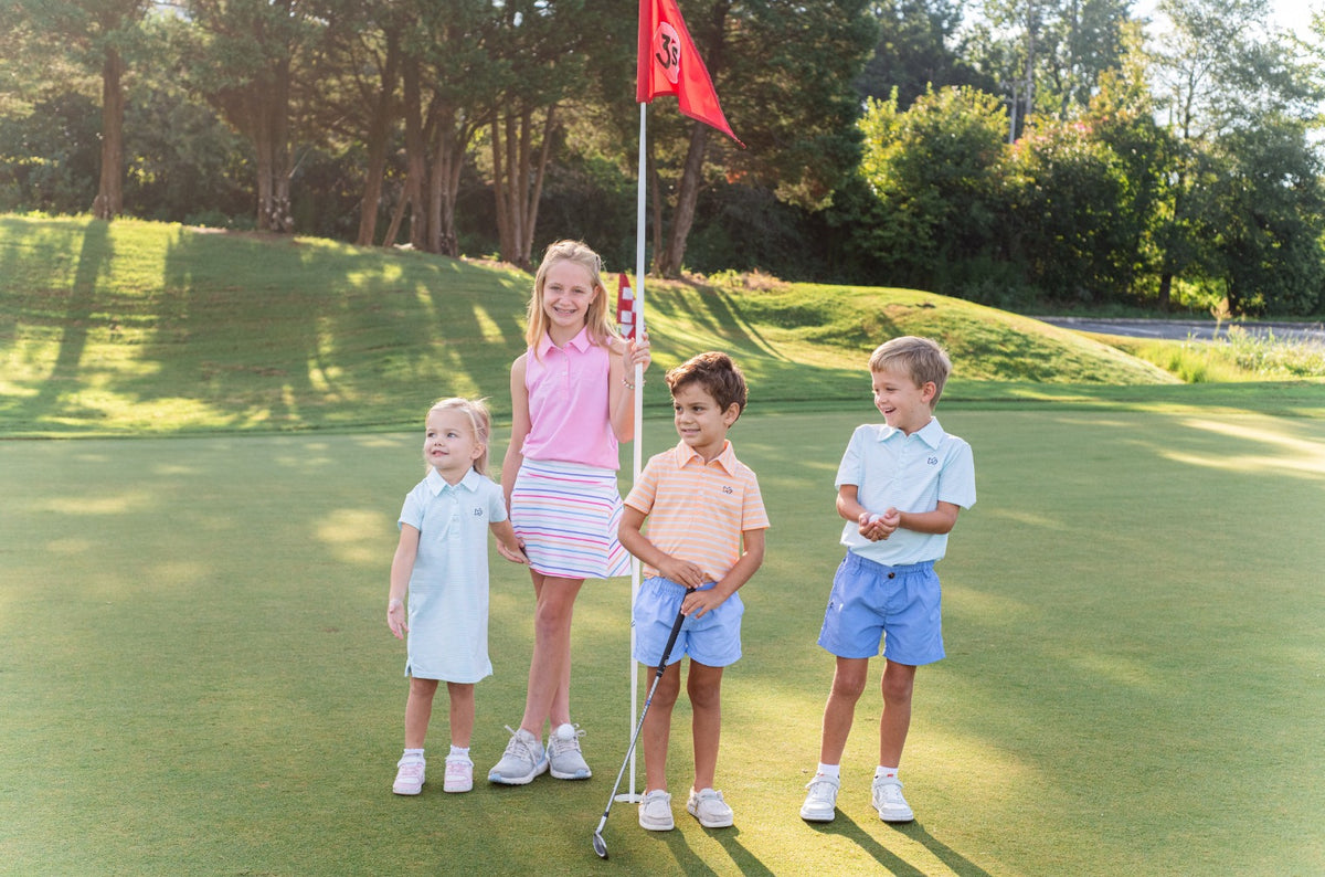 girls with multicolored skort on golf course