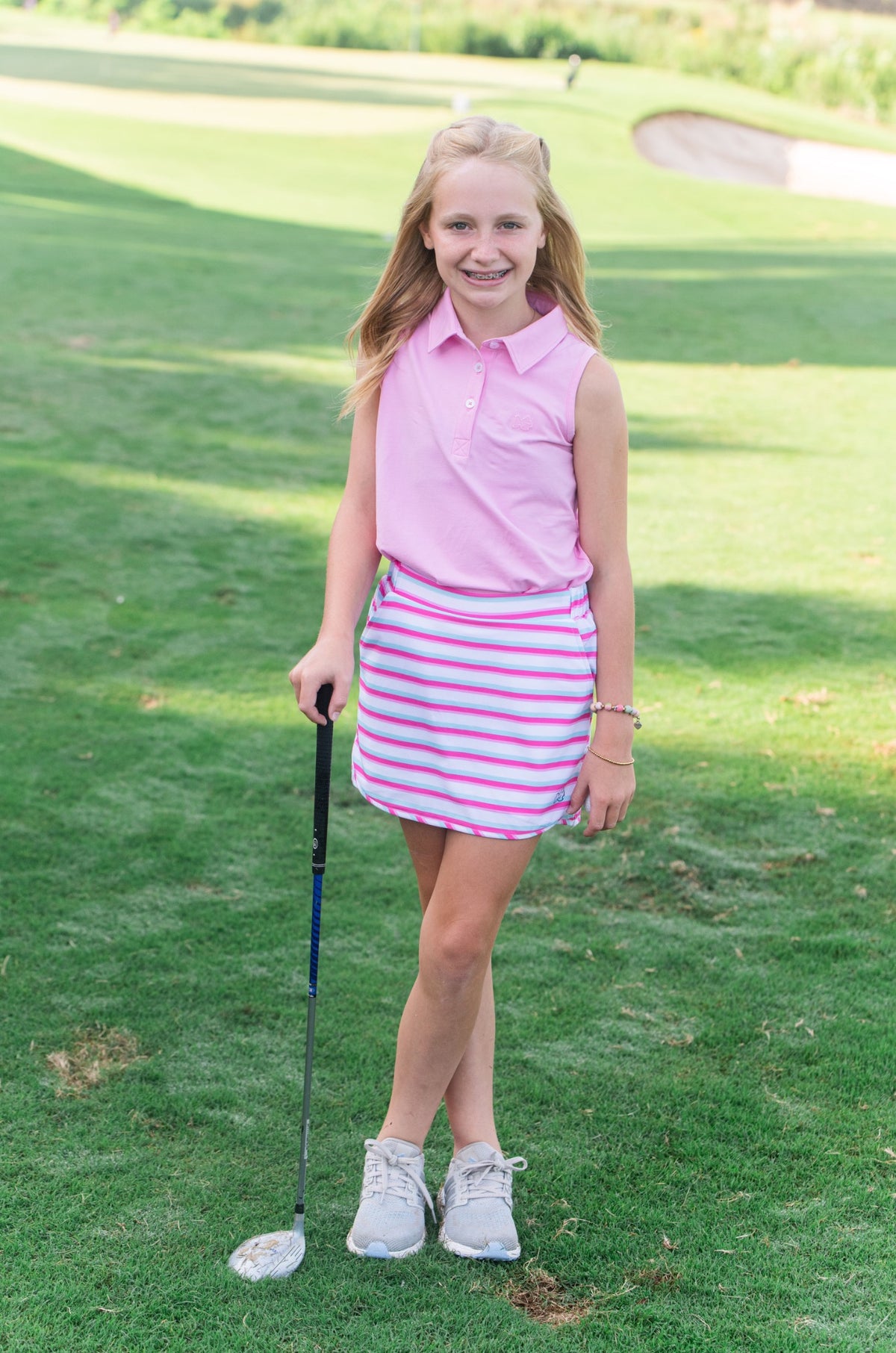 Young girl in pink skort on a golf course