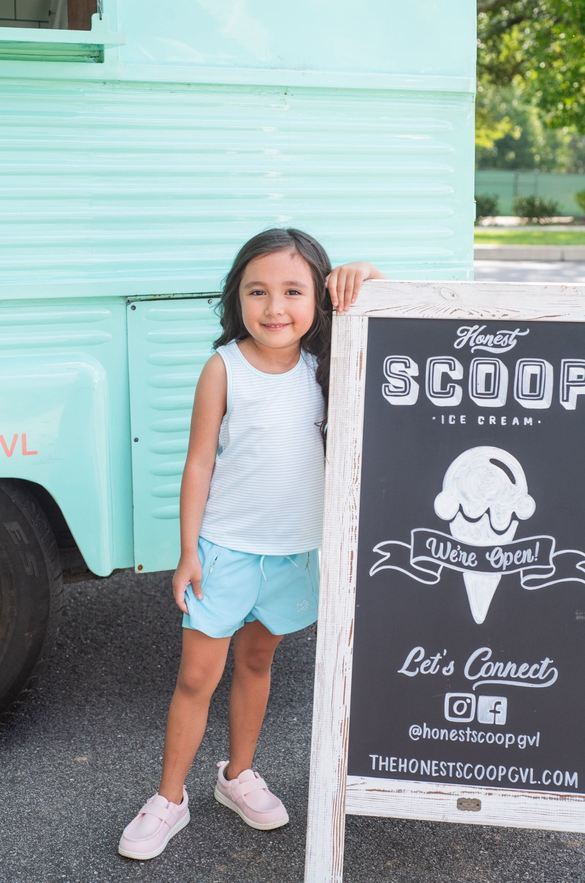 Young girl wearing blue stripe Racerback Tank Top standing next to a ice cream truck