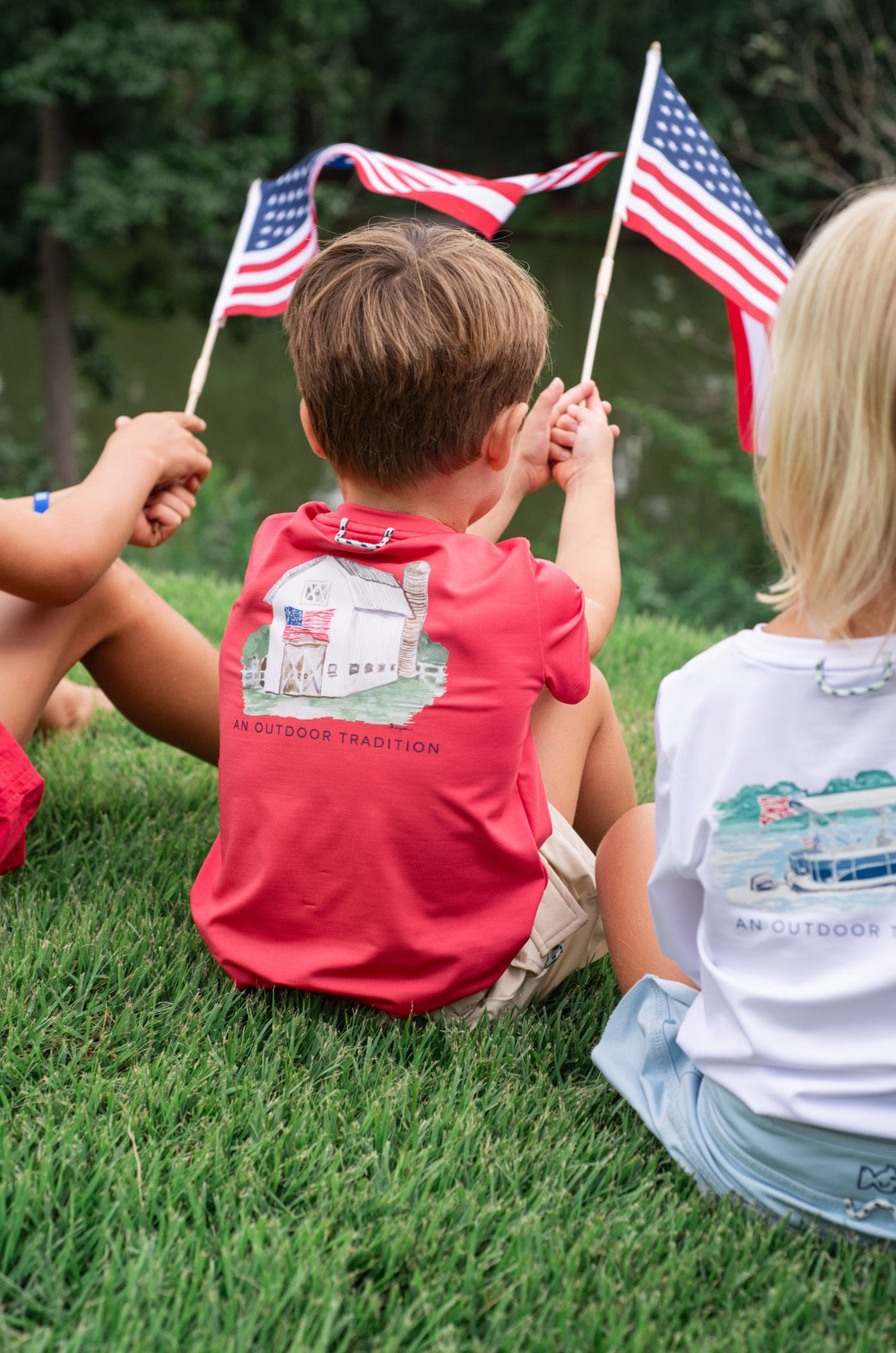 little boy with red performance shirt with american barn art work on the back