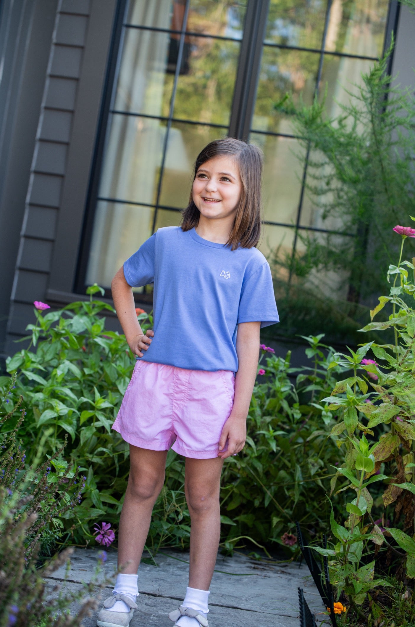 Young girl in a blue shirt and pink Quick-Dry shorts