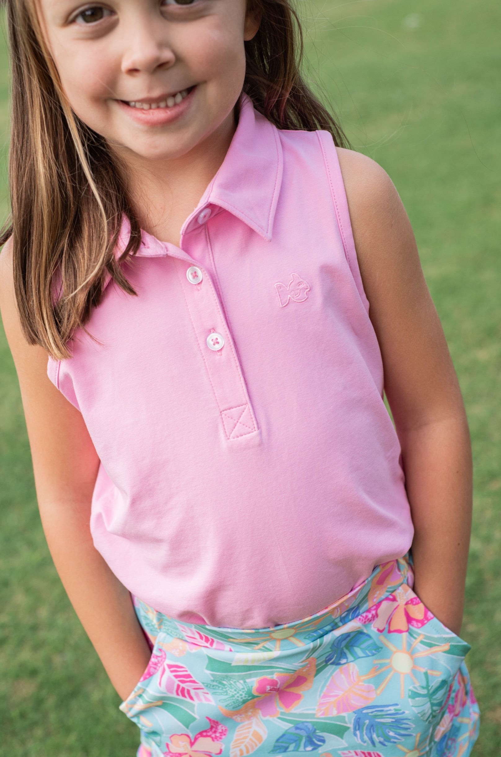 Young girl wearing a pink prodoh carolina catch skort in tropical palm print