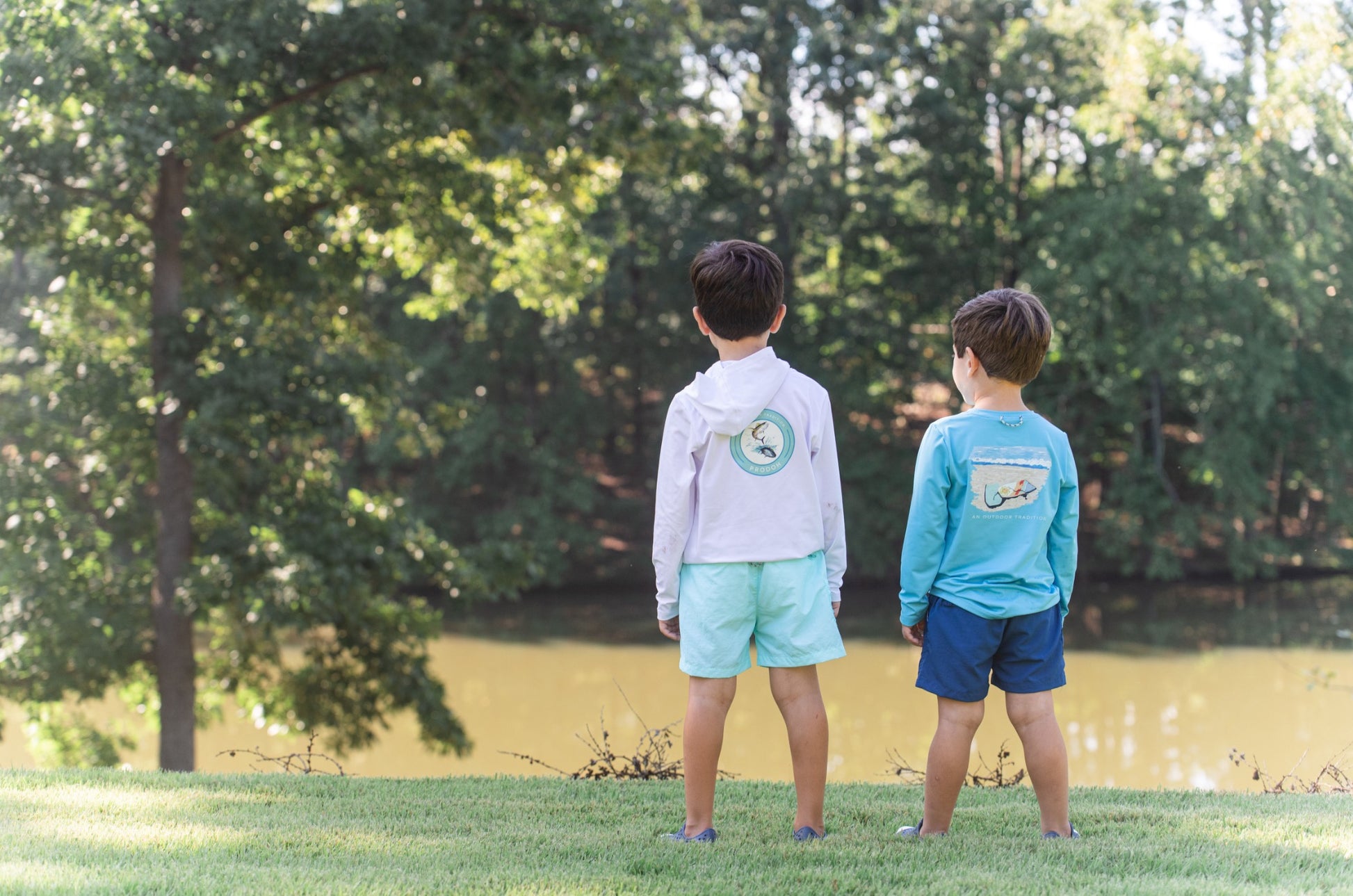 two boys playing in the yard wearing everyday performance shorts