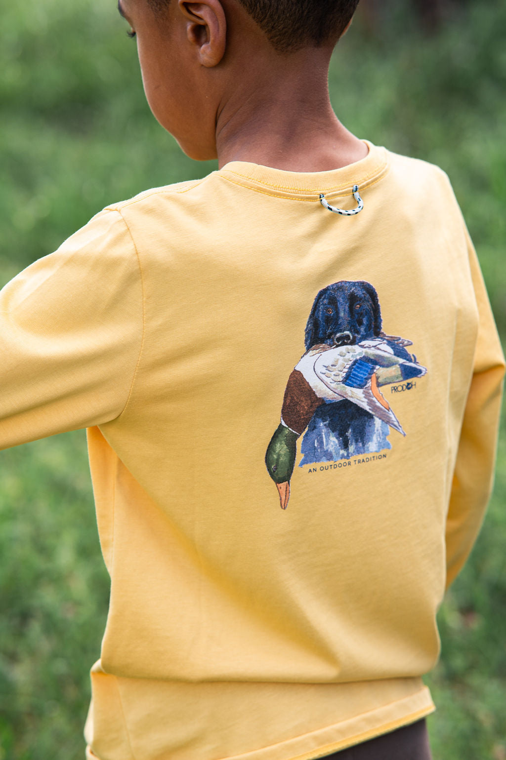 young boy wearing a yellow shirt with a duck graphic