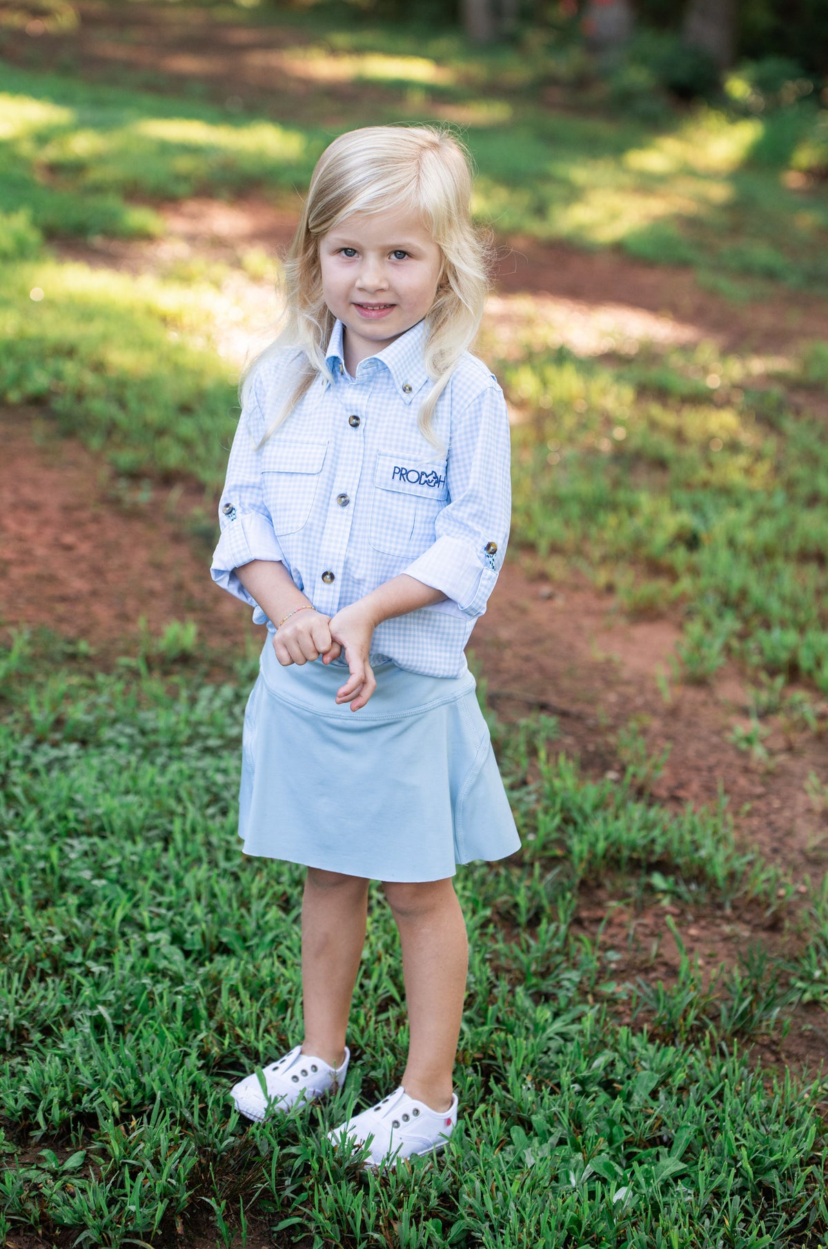 Young girl in a light blue skirt and Long Sleeve Kids Fishing Shirt in Clear Sky in Gingham